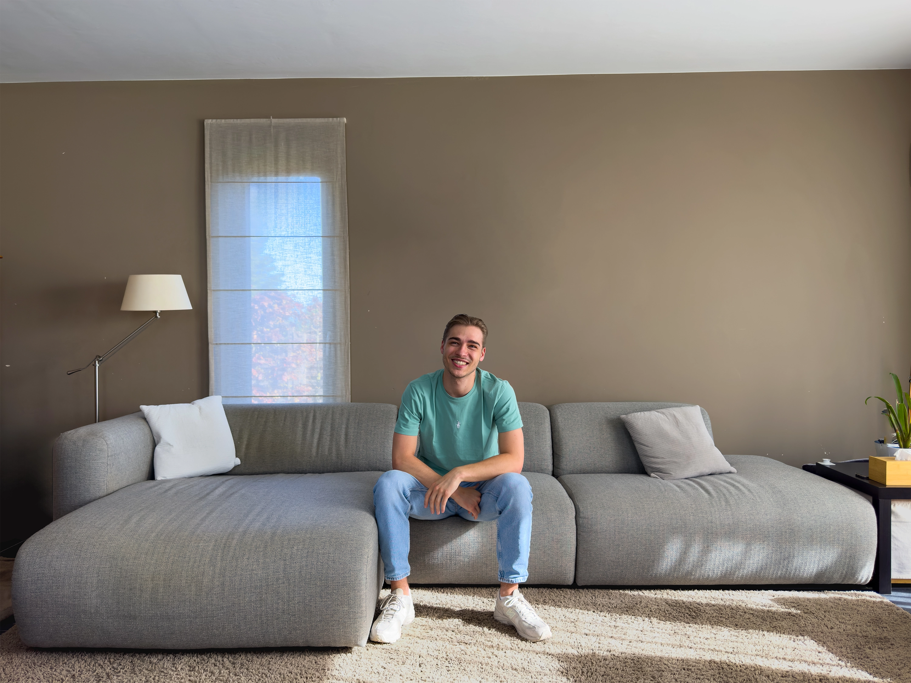 Arthur Haufroid assis sur un fauteuile gris avec un t-shirt bleu